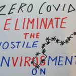 A placard saying 'Zero Covid eliminate the hostile envirusment' (sic)